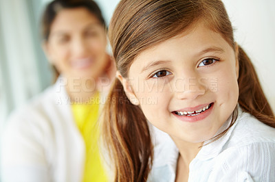 Buy stock photo Blur, parent and portrait of girl in home for fun on weekend in living room of family house. Smile, relax or face of confident kid on couch with mother for happiness, comfort and childhood in Spain