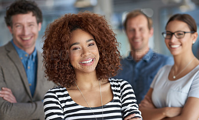 Buy stock photo Portrait of a smiling young woman with friendly coworkers in the background