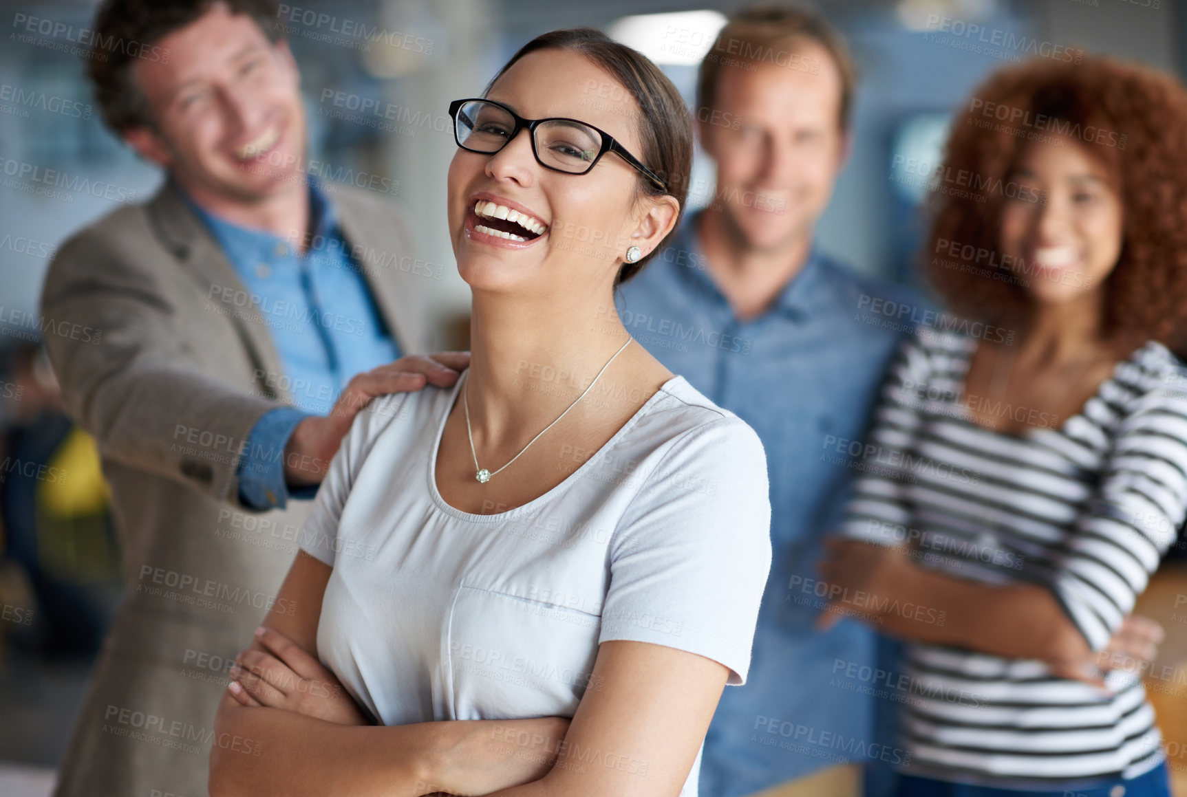 Buy stock photo Young businesswoman laughing happily with supportive colleagues behind her