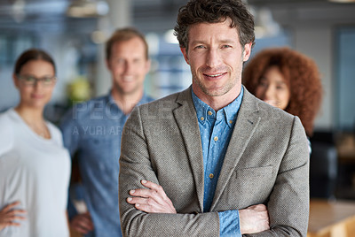Buy stock photo Portrait of a mature serious man with proud coworkers in the background