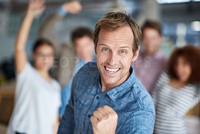 Buy stock photo Smiling mature man posing triumphantly for the camera with happy staff behind him