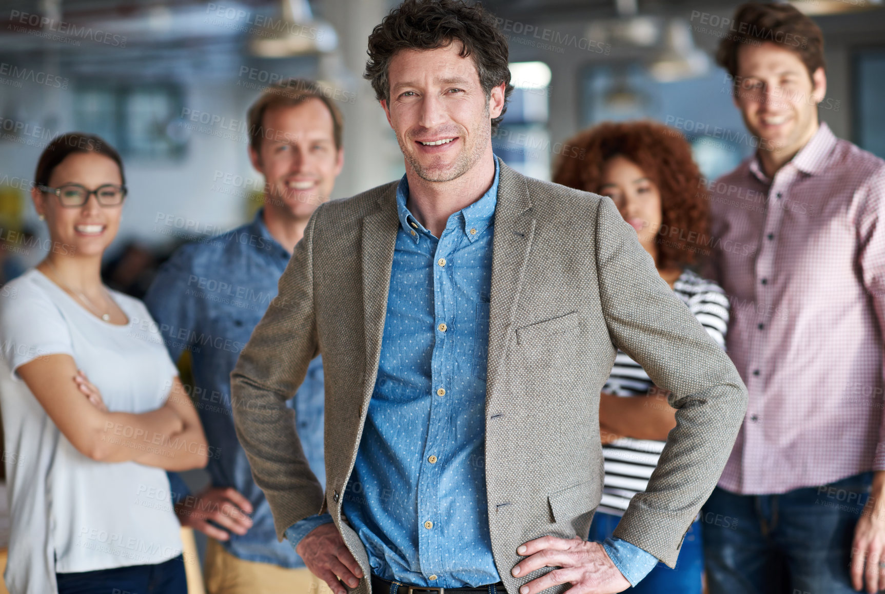 Buy stock photo Smiling mature man posing confidently with colleagues in the background