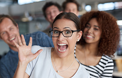 Buy stock photo Young businesswoman acting crazy with laughing coworkers in the background