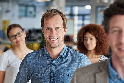 Buy stock photo Mature man smiling amidst coworkers in an office space