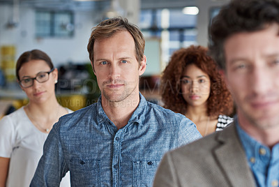 Buy stock photo Portrait of a serious man with colleagues in front of him and behind him