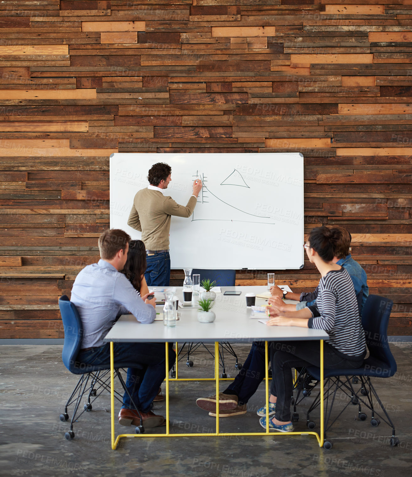 Buy stock photo Shot of a group of coworkers sitting at a conference table during a presentation