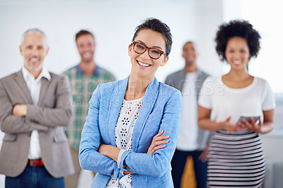 Buy stock photo Beautiful young woman smiling at the camera with colleagues in the background