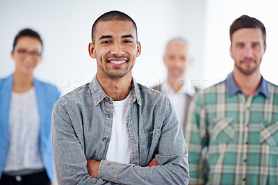 Buy stock photo Young businessman smiling confidently with colleagues in the background