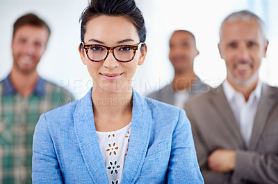 Buy stock photo Beautiful young woman smiling, with colleagues standing in the background