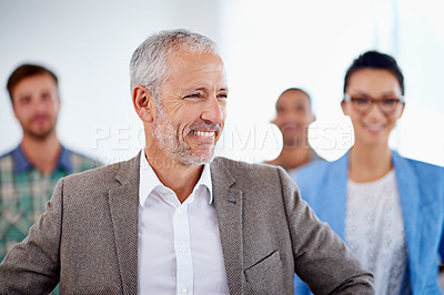 Buy stock photo Smiling mature man looking away with his staff in the background