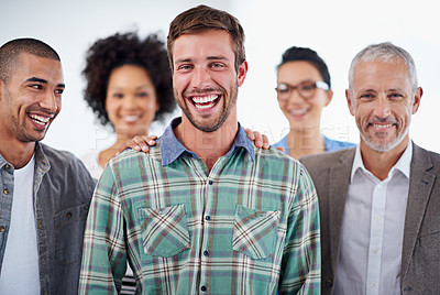 Buy stock photo Handsome young man surrounded by his positive team