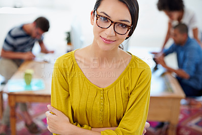 Buy stock photo Young businesswoman looking up at the camera with people working behind her