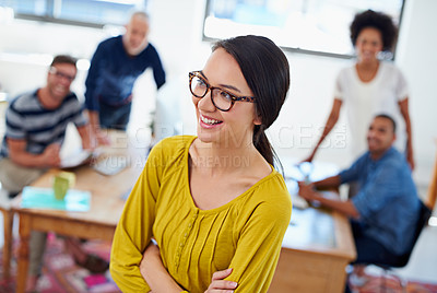 Buy stock photo High angle view of a smiling woman looking away with her colleagues in the background