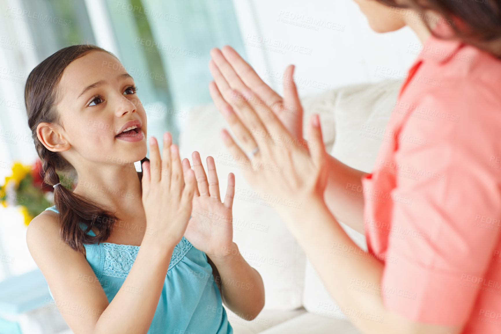 Buy stock photo Mother, child and clapping on sofa for game, cooperation and communication for skills development. Home, mom and girl with playful for bonding, dexterity and coordination with hands in living room