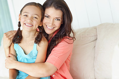 Buy stock photo Cute young mother and daughter embracing while relaxing at home