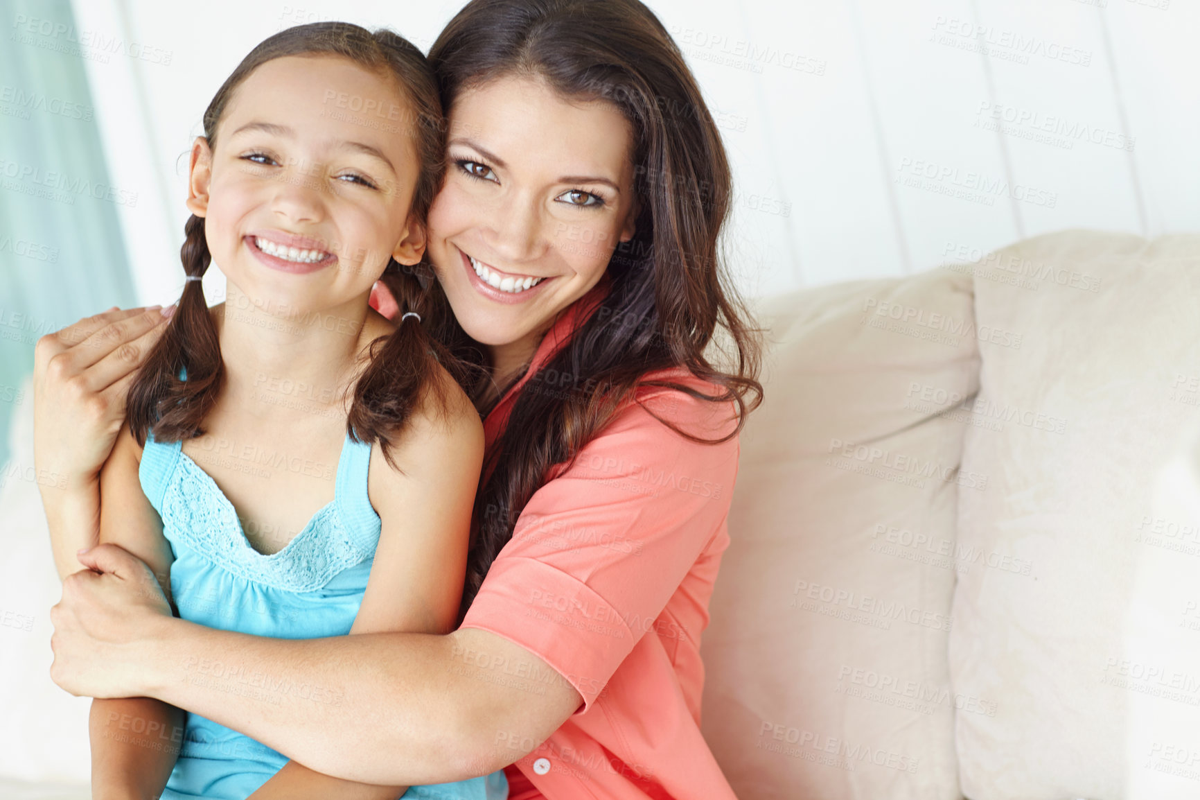 Buy stock photo Cute young mother and daughter embracing while relaxing at home