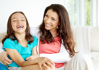 Buy stock photo A mother tickling her daugher while her daughter laughs heartily 