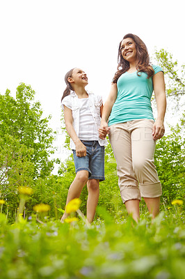 Buy stock photo A mother and daughter standing in a meadow laughing together while holding hands
