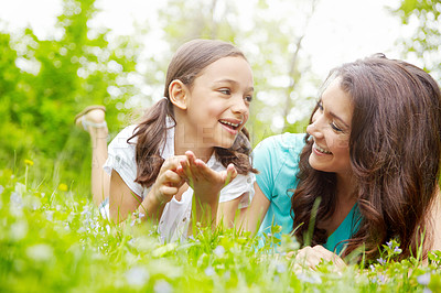 Buy stock photo A mother and daughter lying in the grass of a Meadow while sharing a moment
