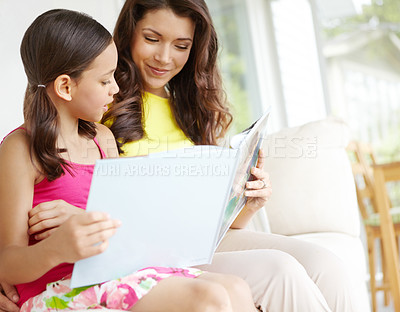 Buy stock photo A mother and daughter reading a book together