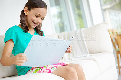 Buy stock photo Book, smile and child on sofa for reading, learning and language development with education in lounge. Home, happy girl and storytelling on couch for cognitive skills, knowledge and fairytale fantasy