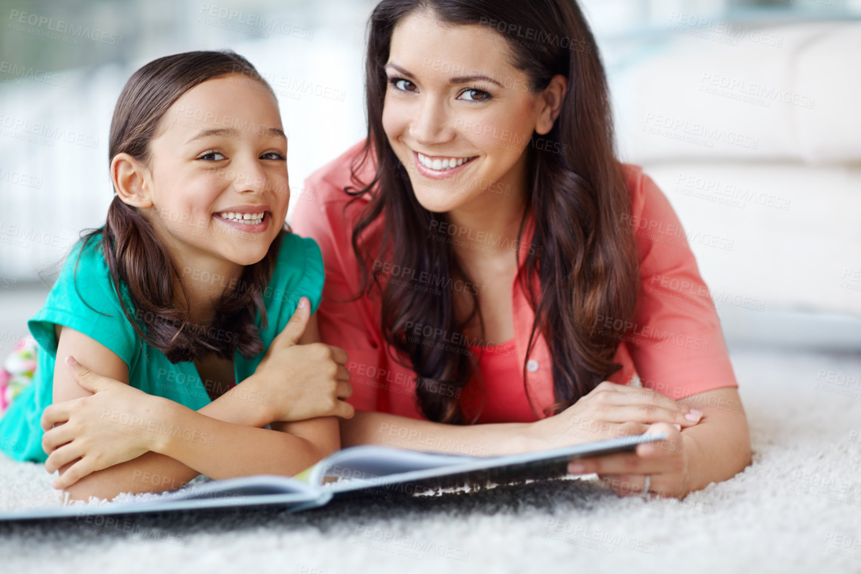 Buy stock photo A portrait of a mother and daughter lying on the floor with a magazine in front of them