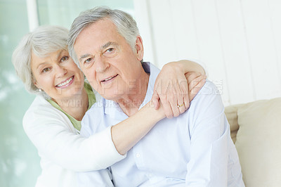 Buy stock photo Hug, love and portrait of old couple on sofa in living room of home together for bonding or commitment. Face, retirement or smile of senior man and woman embracing in apartment for security or trust