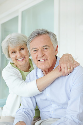 Buy stock photo Hug, love and smile of mature couple on sofa in living room of home together for bonding or commitment. Face, retirement or portrait of senior man and woman embracing in apartment for safety or trust