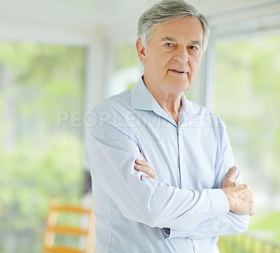 Buy stock photo Senior man, face and relax in home for retirement, confident and weekend with break, peace and leisure. Elderly male, portrait and healthy person on pension for positive mood, comfort or crossed arms