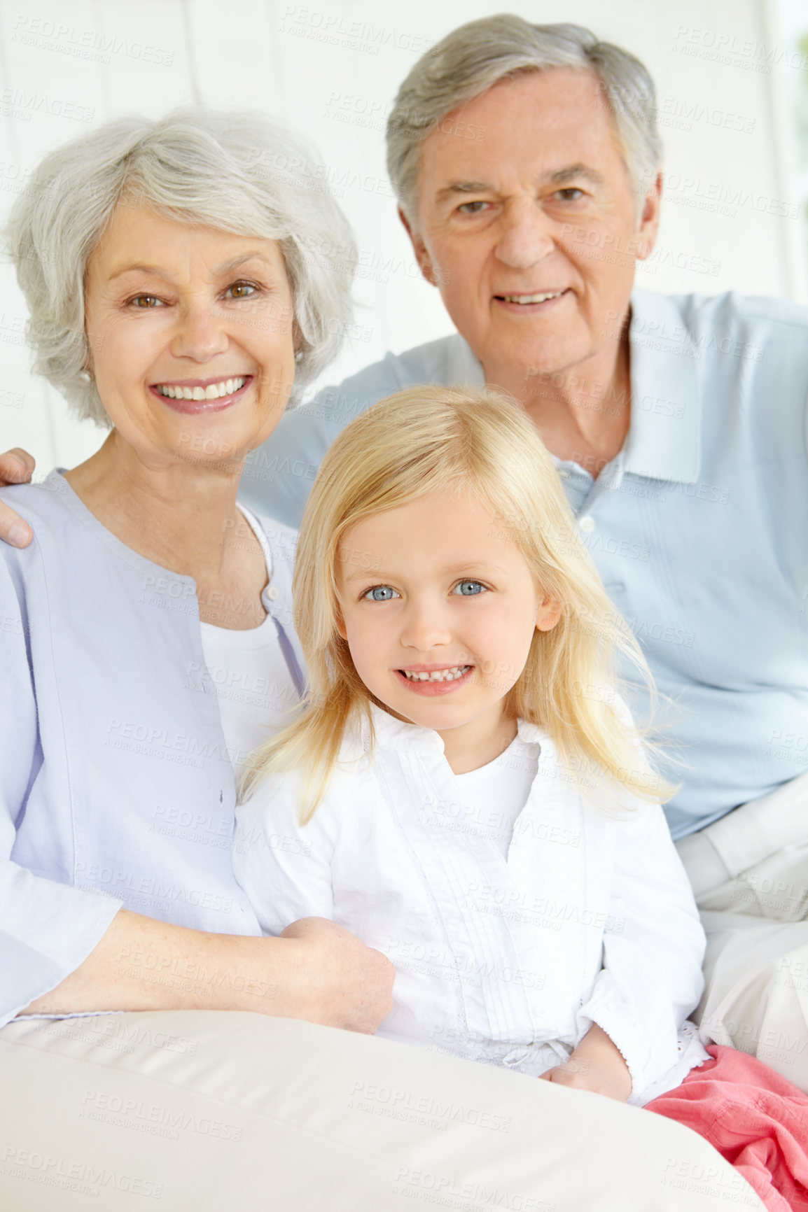 Buy stock photo Grandparents, portrait and smile in home with grandchild for bonding, care and weekend visit on sofa. Elderly people, face and family in living room with little girl for relax, support and connection