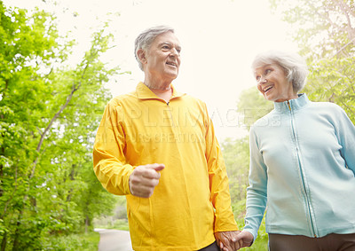 Buy stock photo Senior couple, happy and holding hands for fitness, wellness or outdoor on walk or bonding together. Elderly man, woman and exercise in retirement for health, workout or training as pensioner in park