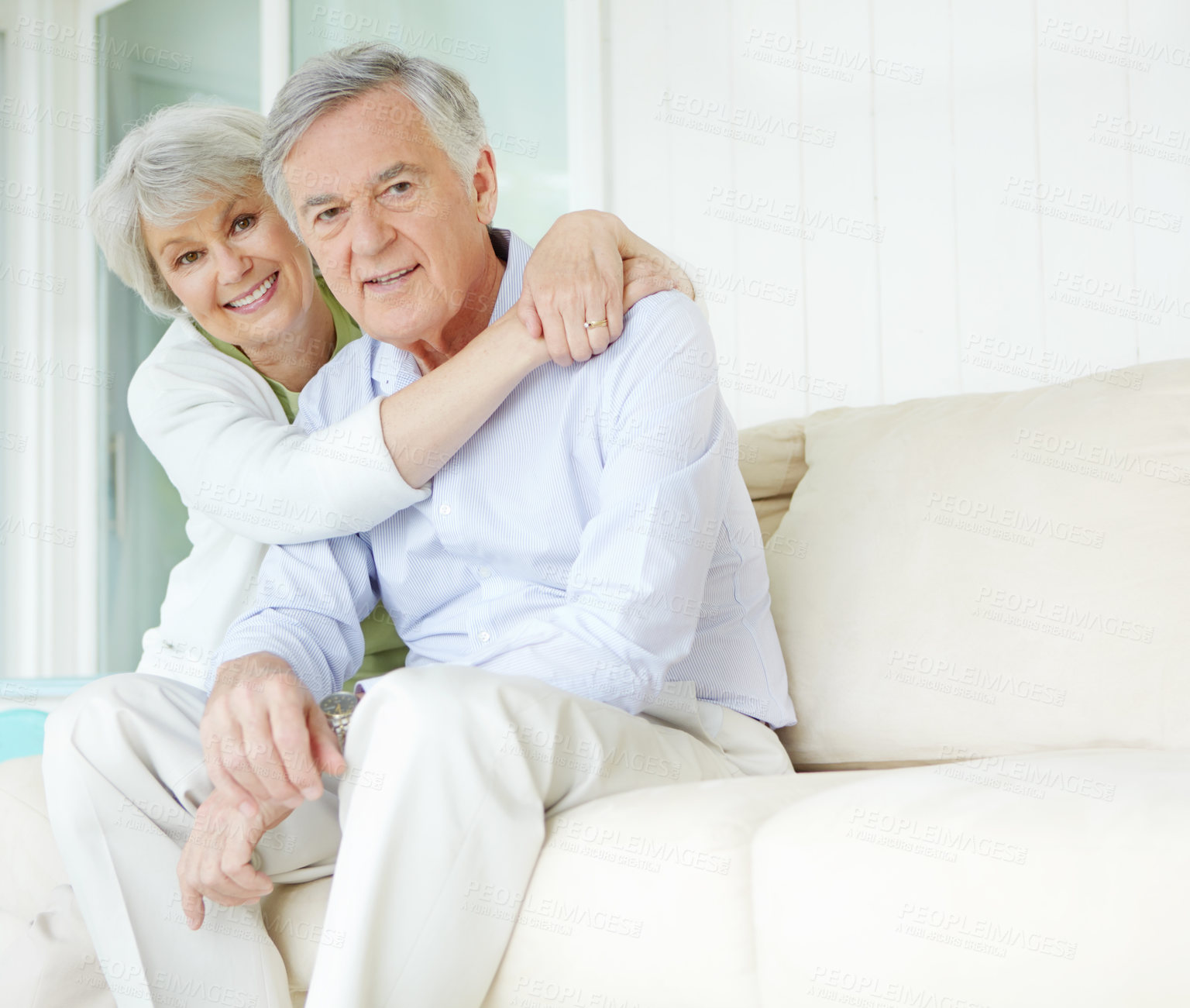 Buy stock photo Hug, retirement and portrait of senior couple on sofa in living room of home together for bonding or commitment. Face, love or smile of old man and woman embracing in apartment for security or trust