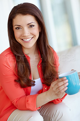Buy stock photo Portrait of a beautiful young woman sitting down at home with a cup of coffee