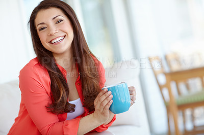 Buy stock photo Portrait of a beautiful young woman sitting down at home with a cup of coffee