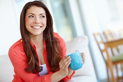 Buy stock photo A beautiful young woman sitting down at home with a cup of coffee