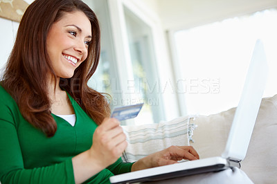 Buy stock photo A beautiful young woman shopping online from the comfort of home