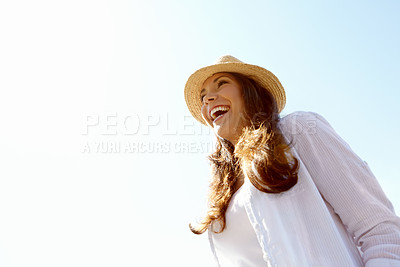 Buy stock photo A beautfiul young woman laughing outdoors against a clear blue sky