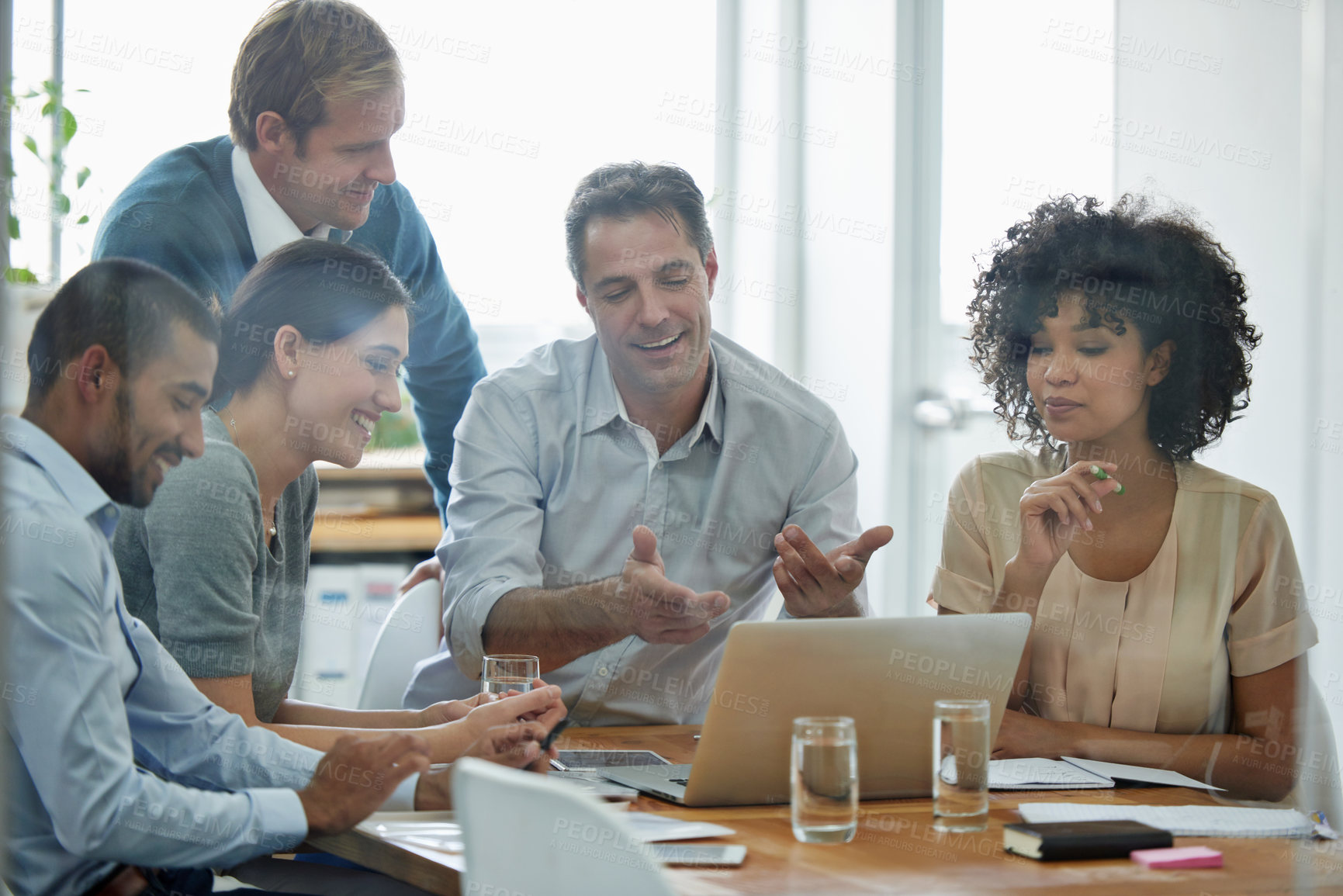 Buy stock photo Shot of a group of professionals using wireless technology during a meeting