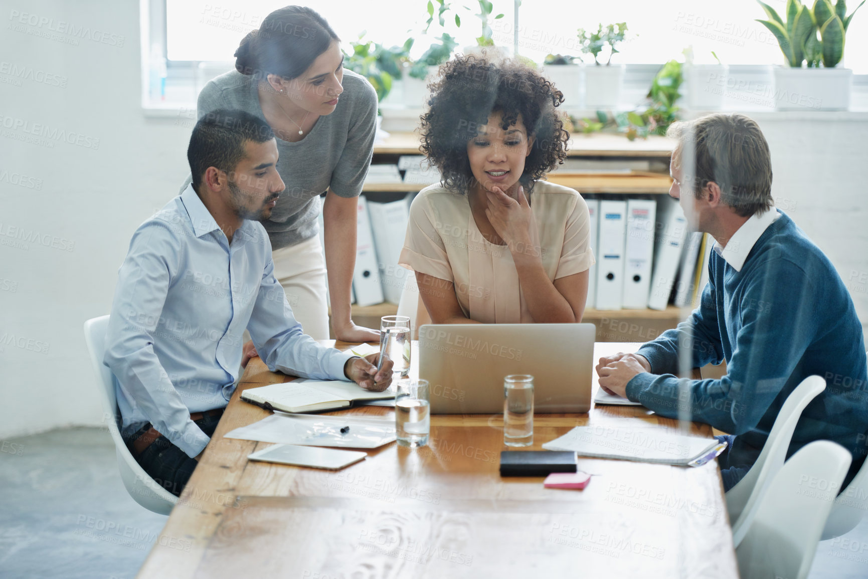 Buy stock photo Shot of a group of professionals using wireless technology during a meeting