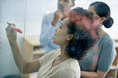 Buy stock photo Shot of a group of creative businesspeople plotting out details on a glass wall