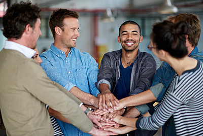 Buy stock photo Positive young ethnic man with his supportive colleagues holding their hands together