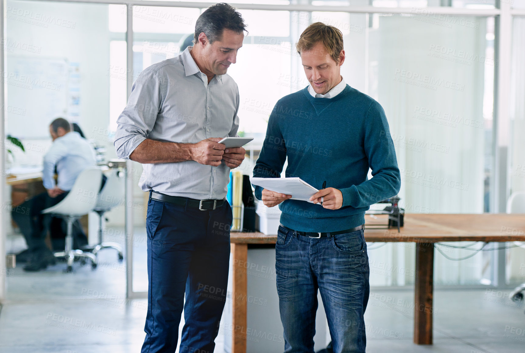 Buy stock photo Meeting, men and tablet with paperwork at startup, collaboration and analysis in discussion for checkup. Conversation, collaboration and evaluation of contract for copyright rules at media agency