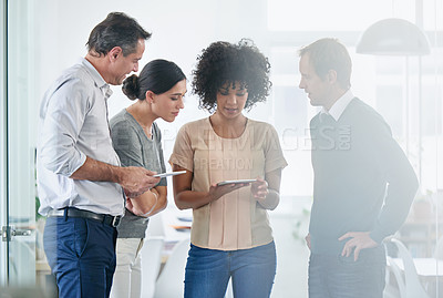 Buy stock photo Shot of a group of colleagues using a digital tablet together in the office