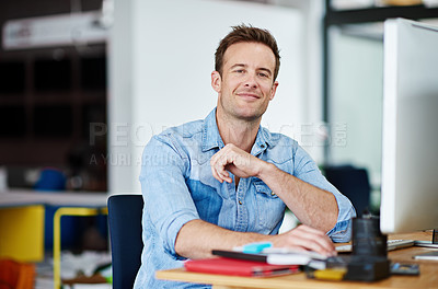 Buy stock photo Portrait of a handsome young man sitting at his desk in an office