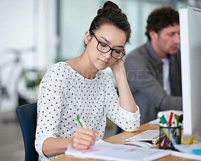 Buy stock photo Shot of a beautiful young woman working at her desk in an office