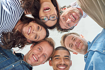 Buy stock photo Low angle shot of six people putting their heads together in a circle