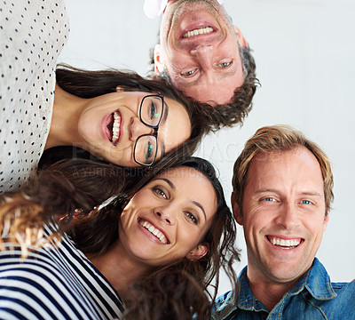 Buy stock photo Low angle shot of a group of people smiling down at the camera positively