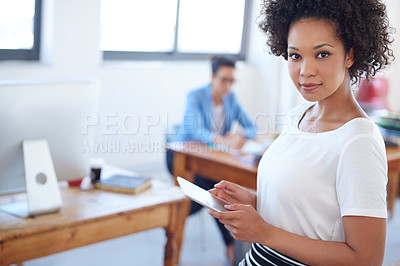 Buy stock photo Beautiful woman looking at the camera while holding a digital tablet with bright office space in the background