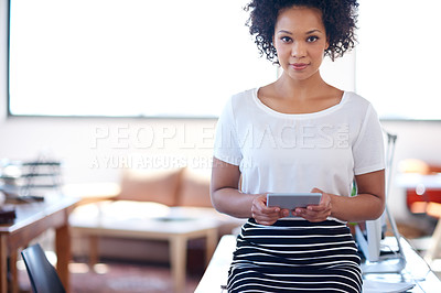 Buy stock photo Beautiful african businesswoman holding a digital tablet with a bright office space in the background