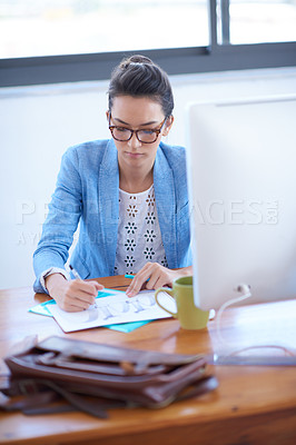 Buy stock photo Young professional woman working diligently at her desk